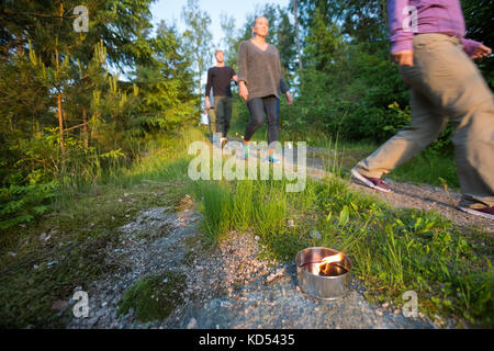 Les gens d'affaires marche sur sentier éclairé par des bougies à réchaud en forêt au cours de randonnées Banque D'Images