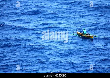 Pêcheur solitaire dans l'immense mer bleue Banque D'Images