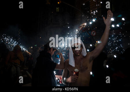 Les gens s'amusent au Correcos de la Merce. La partie consiste à fuir les démons (Diables) qui jettent des étincelles. Alamy / Carles Desfilis Banque D'Images