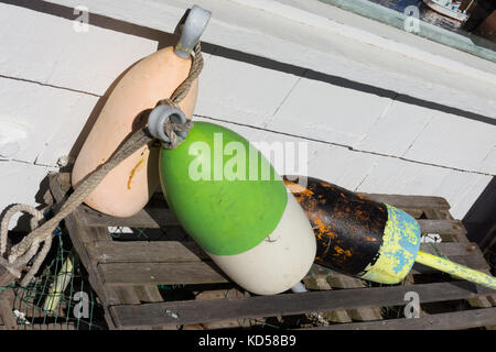 Close up of a lobster pot au sommet d'une des bouées en bois patiné lobster pot photographié à un angle de lumière naturelle. Banque D'Images
