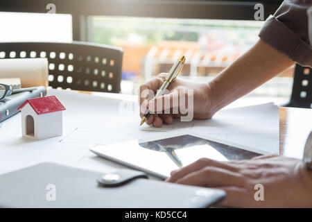 Ingénieur et architecte, ingénieur concept bureau de travail de l'équipe d'architectes et de discuter de plans de maison modèle, effet vintage Banque D'Images