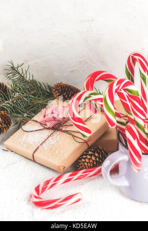 Le temps de Noël, branches d'arbre de Noël concept, pommes de pin, des cadeaux et des bonbons traditionnels nouvelle année canne de Noël, sur une table de marbre blanc de neige. copie Banque D'Images