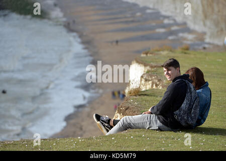 Les touristes se trouve près du bord de l'effondrement des falaises de craie à Birlng Gap, East Sussex Banque D'Images