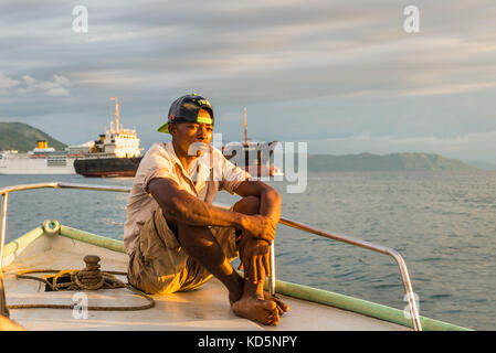 2015 : malagasy batelier naviguant dans les rayons du soleil couchant sur le bateau dans andavakotakona bay, près de l'enfer-ville, l'île de Nosy Be, Madagascar. Banque D'Images