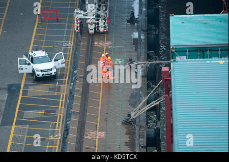 Débardeurs sur le dock avec un porte-conteneurs au port de Felixstowe Banque D'Images