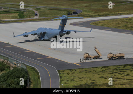 Les aviateurs américains débarquer un C-17 Globemaster, chargé avec des soldats américains affectés à la 18e Brigade d'artillerie de campagne, Fort Bragg, NC et deux M142 HIMARS Banque D'Images