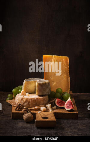 Plateau de fromages, fruits et noix sur le bois brut Banque D'Images