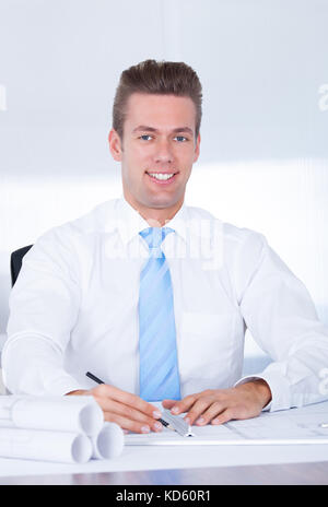 Close-up of male architect travaillant sur blueprint at desk Banque D'Images