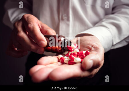 Verser des capsules de médicaments d'ordonnance d'une bouteille de pilule dans la main Banque D'Images