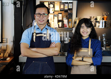 Portrait of smiling asian barista équipe avec les bras croisés au comptoir à café. café restaurant service, propriétaire de petite entreprise, de l'alimentation et boissons l'indu Banque D'Images