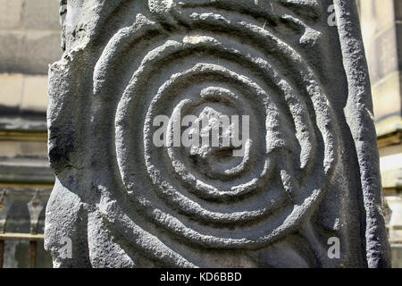 Close up de volutes en spirale sur une croix médiévale, All Saints' churchyard, Bakewell, Derbyshire. Banque D'Images