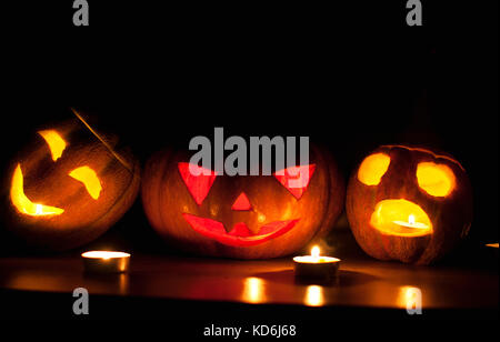 Scary Halloween Pumpkin et melon jack-o-lanternes sur fond noir allumé des petits et star des bougies. selective focus, bokeh. Banque D'Images