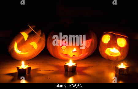 Scary Halloween Pumpkin et melon jack-o-lanternes sur fond noir allumé des petits et star des bougies. selective focus, bokeh. Banque D'Images