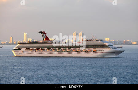 Miami, USA - Le 11 décembre 2010 : Carnival Liberty de quitter le port de Miami au coucher du soleil. Le navire de croisière est l'un des plus grands paquebots exploités par carniva Banque D'Images