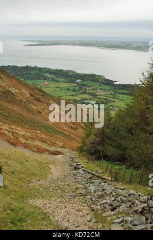 Vieux mur vers le bas en remontant le flanc d'une montagne avec Carlingford Lough en arrière-plan, rostrevor, Irlande du Nord Banque D'Images