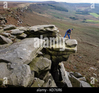 Un grimpeur appelle à son contact dans un surplomb sur Stanage Edge près de Hathersage dans le Derbyshire Peak District UK Banque D'Images