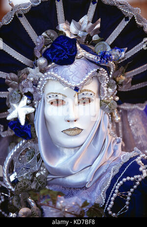 Italie. Venise. Carnaval. Femme en costume. Gros plan du visage avec masque blanc.