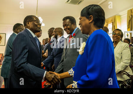 Harare. 10 octobre 2017. Le président zimbabwéen Robert Mugabe (G, Front) félicite Thokozile Mathuthu (R, Front) après avoir prêté serment en tant que nouvelle ministre d'État pour le Matabeleland Nord à la State House à Harare, Zimbabwe, le 10 octobre 2017. Le président zimbabwéen Robert Mugabe a prêté serment mardi six nouveaux ministres qu'il a nommés lors d'un remaniement ministériel lundi. Crédit : Xinhua/Alamy Live News Banque D'Images