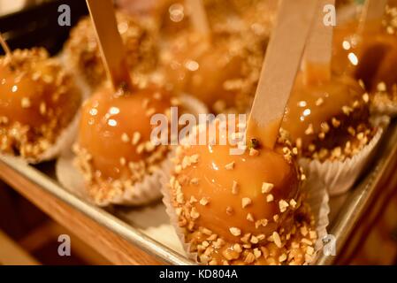Pommes au caramel couverts d'arachide sur un bâton en bois à vendre à seaquist orchards farm market, sister bay, comté de porte, au Wisconsin. Banque D'Images