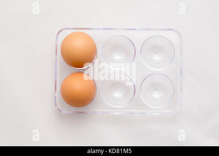Bac d'oeufs, deux œufs, six oeufs de moins quatre, isolé sur fond blanc Banque D'Images