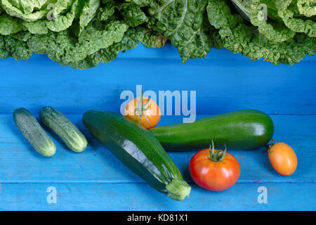 Les légumes. tomates, concombres, courgettes et chou. Les aliments biologiques sur fond de bois bleu rustique. Banque D'Images