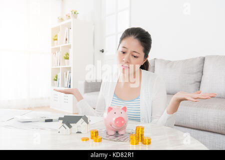 Triste belle femme veulent acheter nouvelle maison pour sa famille, mais pas assez de fonds et de rendre impuissant posing looking économies à se sentir déprimé. Banque D'Images