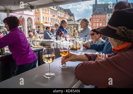 Une femme à boire un verre de pinot noir Spatburgunder Ruwer vin au kiosque, vin, place du marché Hauptmarkt, Trèves, Rhénanie-Palatinat, Allemagne Banque D'Images