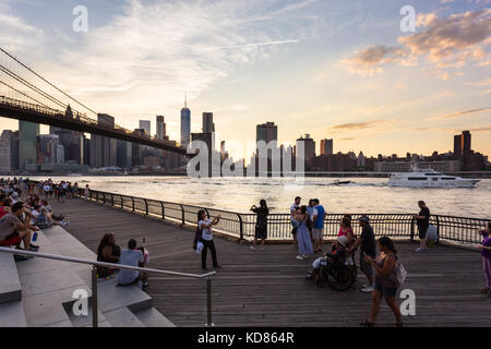 New York - 3 juillet 2017 : les gens aiment le coucher du soleil sur le quartier financier de Manhattan et l'East River à partir du pont de Brooklyn Park à New yo Banque D'Images