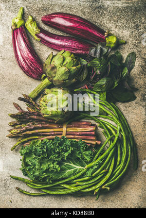 Télévision à jeter toutes sortes de légumes vert et violet sur fond de béton, vue du dessus. Produits locaux de saison pour la cuisine saine. Eggplans, haricots verts, Banque D'Images