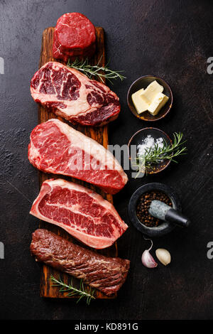 Variété de matières premier Black Angus Steak viande machette, lame sur l'os, le filet, le faux-filet, filet mignon sur planche de bois et l'assaisonnement Banque D'Images