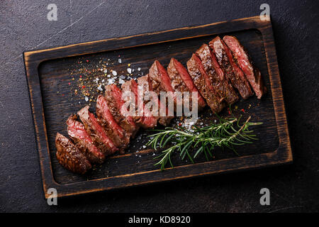 Tranches de viande grillé Steak barbecue machette sur fond sombre Banque D'Images