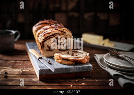 Pain tressé chocolat chaud de pain sur une en pension dans un cadre rustique en bois. Banque D'Images