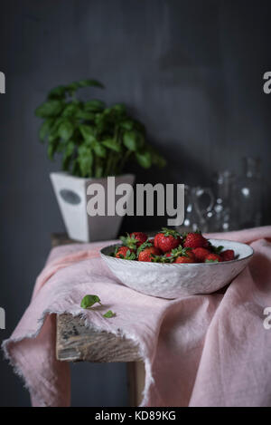 Fraises fraîches dans un bol dans une cuisine rustique Banque D'Images