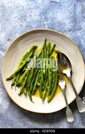 Haricots verts sautés à l'huile d'olive et l'ail dans un plateTop view Banque D'Images