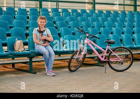 Enfant sports posant avec la moto. Petite fille sur les sièges du stade. Banque D'Images