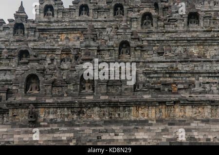 Un fragment de l'extérieur du Temple de Borobudur avec des statues de Bouddha assis dans des créneaux, Yogyakarta, Java centrale, Indonésie Banque D'Images