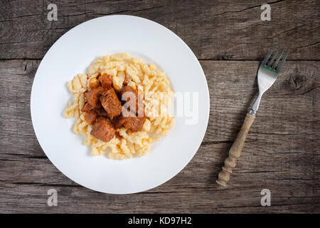 Goulash de bœuf avec nouilles aux œufs sur une assiette à fourchette Banque D'Images