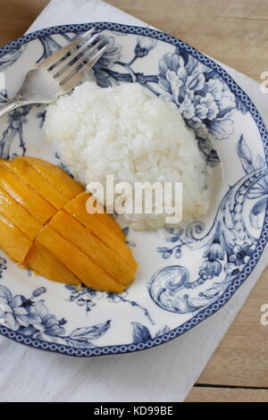 Sweet thai riz collant avec tranches de mangue sur plaque bleue sur conseil blanchâtre Banque D'Images