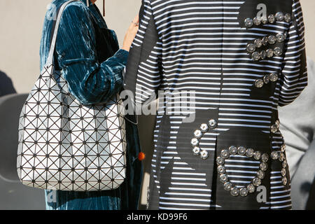 Milan - 20 septembre : femme avec manteau rayé noir et blanc et argent sac géométrique avant d'alberto zambelli fashion show, Milan Fashion week street Banque D'Images