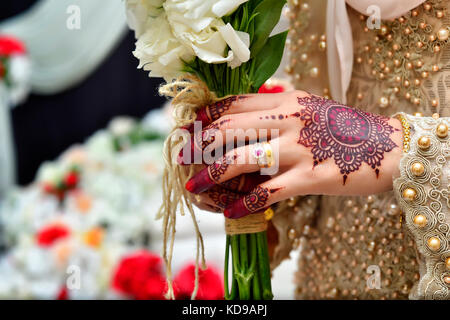 Femme bride holding bouquet de mariage avec tatouage au henné Banque D'Images