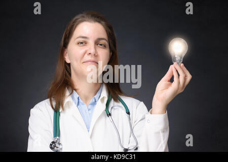 Médecin femme tenant une ampoule incandescent Banque D'Images