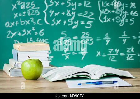 Les manuels scolaires sur un bureau in front of blackboard Banque D'Images