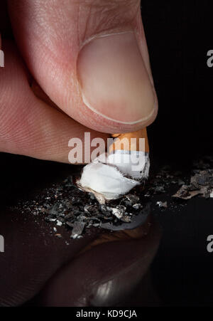 Extreme close-up d'une cigarette d'écrasement des mains Banque D'Images