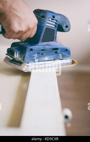 Le ponçage et la préparation des vieilles portes avec peinture craquelée pour une nouvelle couche de peinture lisse, ponçage ou décapage de concept. Banque D'Images