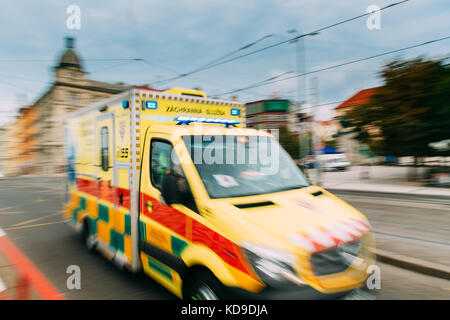 Prague, République tchèque. déménagement avec sirène d'urgence réanimation ambulance jaune vif van voiture sur rue. ambulance dans blurred motion Contexte Banque D'Images