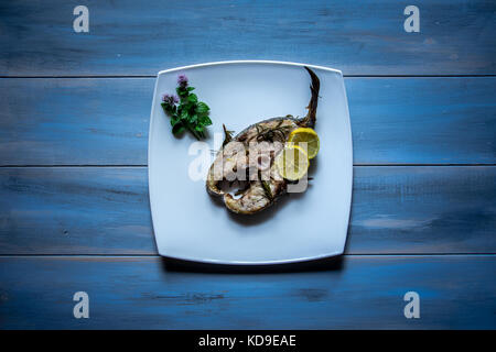 Sériole yellowtail grillé avec des tranches de citron sur fond de bois. Banque D'Images