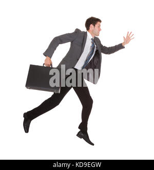 Businessman running avec serviette à main sur fond blanc Banque D'Images