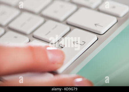 Photo en gros plan des mains appuyant sur la touche Entrée du clavier Banque D'Images