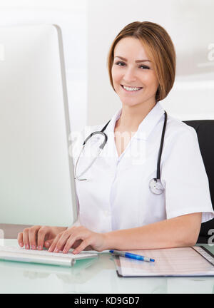 Portrait of happy young woman working on computer Banque D'Images
