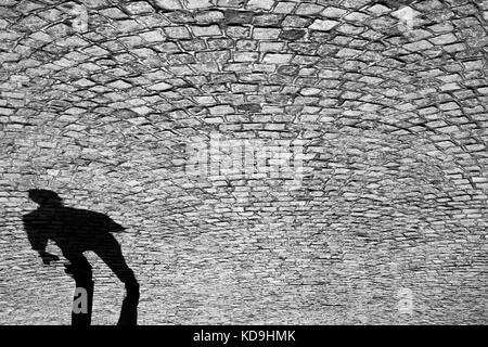 Ombre floue d'un homme qui marche sur l'ancienne route pavée Banque D'Images